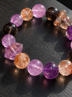 Close-up of natural amethyst, black gold Super Seven and smoky quartz beads with a double-terminated amethyst accent