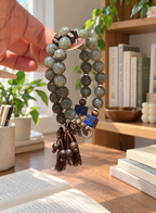 Hand holding a natural Hetian jade and agarwood bracelet with lapis lazuli cube accent