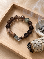 Ice Obsidian and agarwood bracelet displayed in a minimalist crystal purification and mindful ritual setting