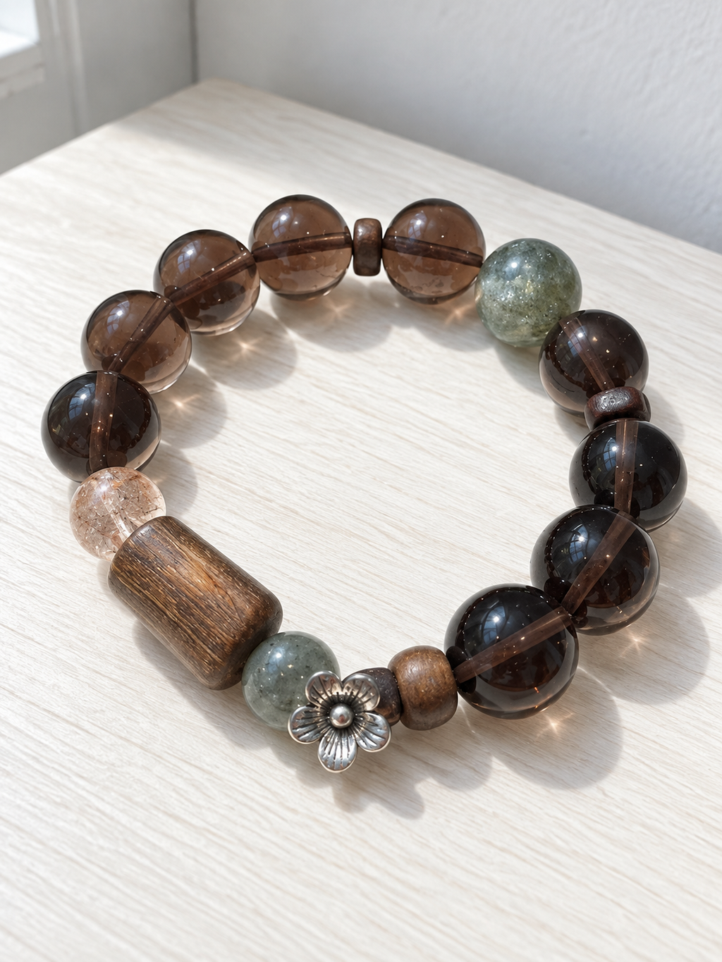 Natural Ice Obsidian bracelet with green crystal, agarwood plaque and Black Gold Super Seven beads in a 14mm design
