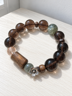 Natural Ice Obsidian bracelet with green crystal, agarwood plaque and Black Gold Super Seven beads in a 14mm design